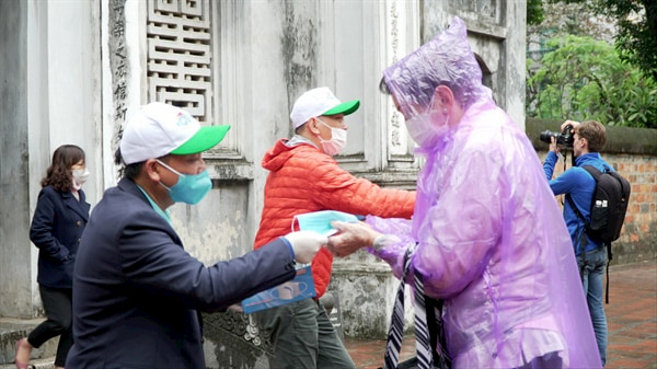 Cau lac bo lu hanh UNESCO Ha Noi phat khau trang mien phi cho du khach quoc te tai Van Mieu